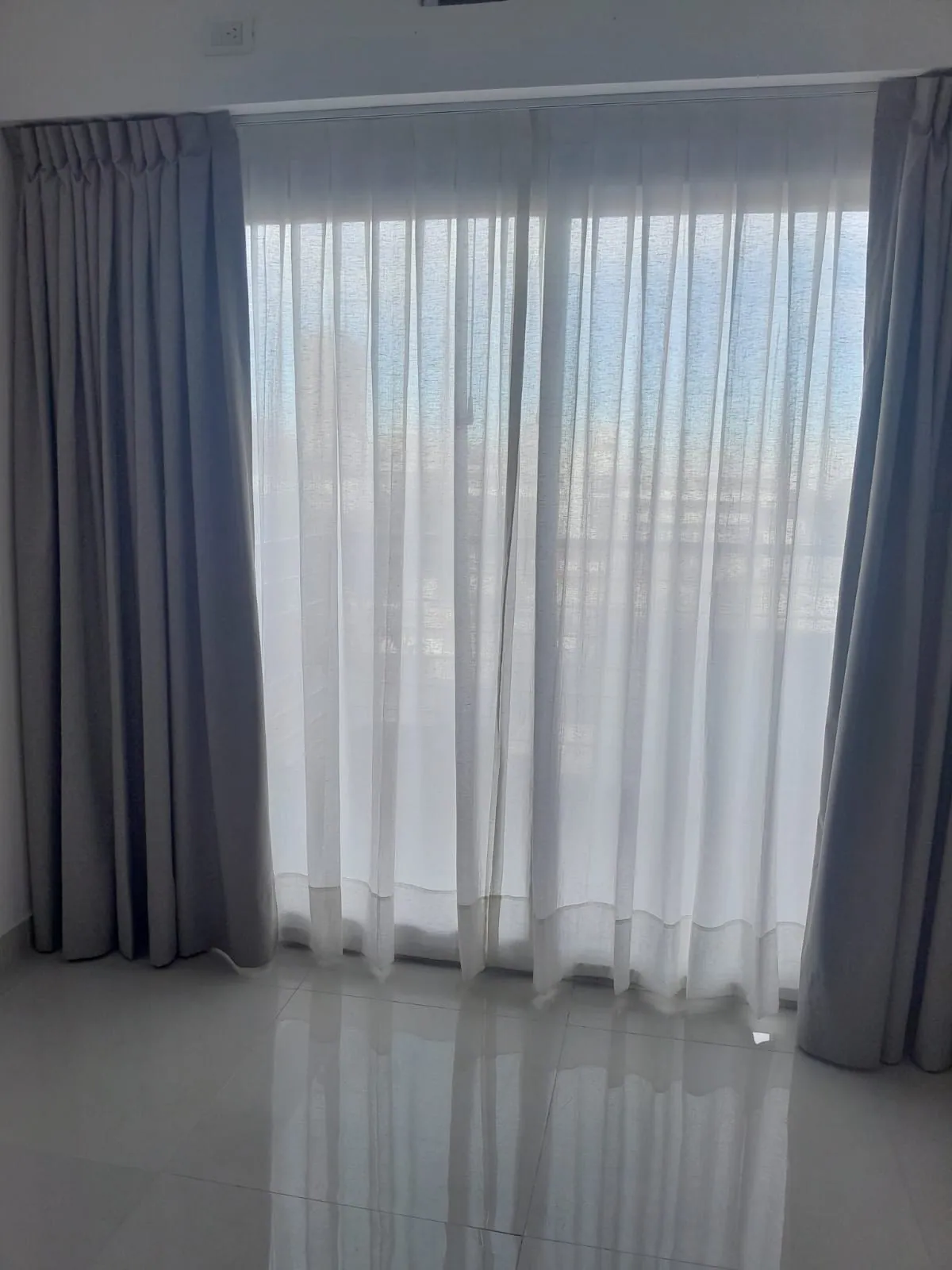 Cortinas de gasa del piso al techo en un ambiente luminoso con piso claro